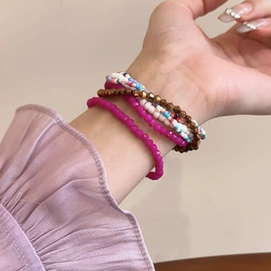 Detail of colorful multi-layer beaded bracelets with stars on a model's wrist