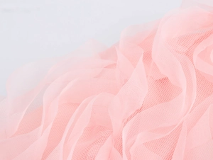 Vue macro détaillée du tissu en maille 3D rose avec textures ondulées et plis de dentelle