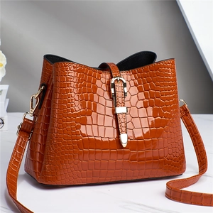 Close-up of caramel crocodile pattern tote bag with polished finish and gold metal buckle