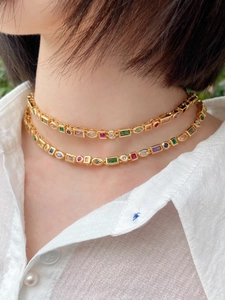 Close-up of double-layer gold necklace featuring vibrant colorful zircon gemstones on model