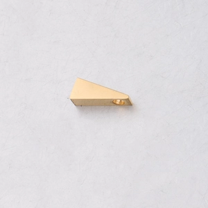 Detailed macro view of a golden triangular stainless steel pendant with a threaded hole