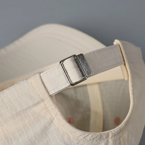 Detail of adjustable metal buckle and checkered quick-dry fabric on the baseball cap