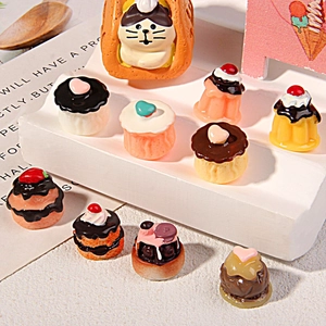 Miniature resin chocolate and vanilla cupcakes with heart toppers on a display stand