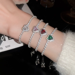 Close-up of four heart-shaped crystal bracelets in white, pink, red, and emerald green