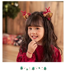 Detail of Christmas headband with red reindeer antlers, brown ears, and pine cone decor