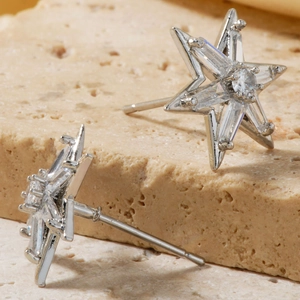 Macro view of silver star earrings with sparkling cubic zirconia on a stone surface