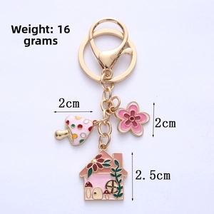 Detail of pink alloy keychain showing 2.5cm house and flower charms weighing 16g