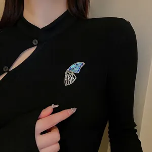 Elegant hollow butterfly brooch with blue enamel and crystals on black fabric