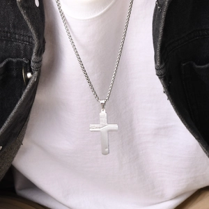 Men's stainless steel necklace featuring a cracked cross pendant worn by a model