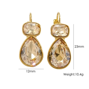 Detail of drop earrings with cushion and pear-cut champagne crystals in golden finish