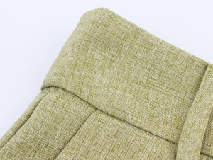 Macro view of light green linen-style fabric showing belt loops and pleated waistband details