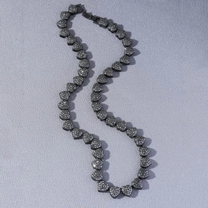Detail of hip hop cuban chain featuring black metal heart links with sparkling rhinestones