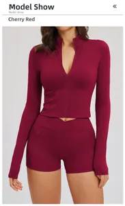 Close-up of cherry red sports set featuring half-zip top and high-waist shorts with pockets