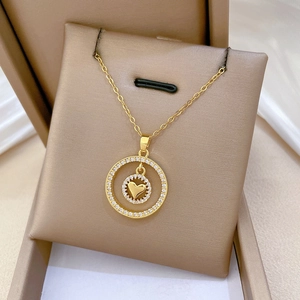Dettaglio della collana con pendente a cuore e cerchio dorato in scatola regalo