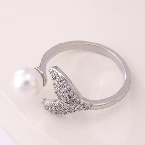 Macro detail of silver fishtail ring with white pearl and sparkling zircon inlay