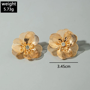 Gros plan sur les boucles d'oreilles fleurs dorées de 5,73g et 3,45cm de diamètre