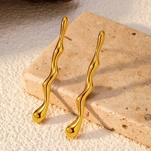 Macro detail of wave-shaped fluid metal earrings in 18K gold plated stainless steel