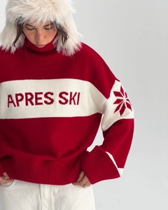 Detail of Après Ski lettering on red knit sweater with snowflake sleeve embroidery