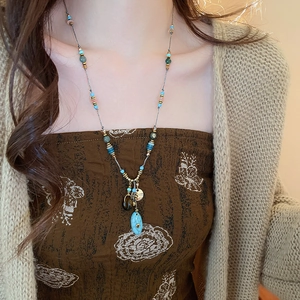 Dettaglio della collana lunga bohémien con ciondolo in turchese su una modella