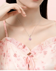 Close-up of a pink heart gemstone necklace with pavé diamonds on a silver chain