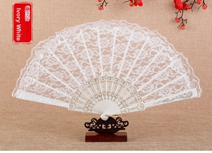 Detail view of ivory white lace folding fan with intricate floral patterns and golden bone