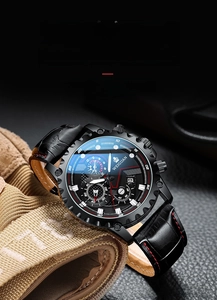 Detail of all-black tactical watch dial with date window and red-stitched leather strap