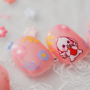 Pink press-on nails featuring cute bunny and colorful floral patterns in glossy finish