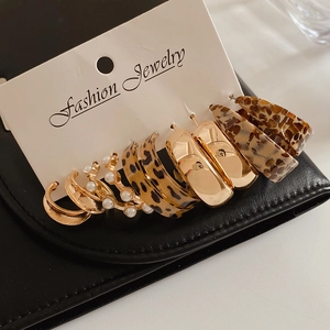 Detailed view of 6-piece leopard print and gold pearl C-shape earring set on a display card