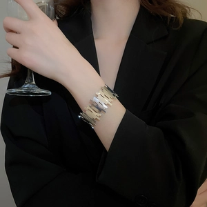 Close-up of irregular textured silver cuff bracelet on a model wearing black suit