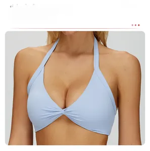 Detail of light blue halter yoga bra featuring a front twist design and V-neckline