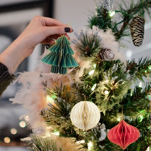 Close-up of three mini honeycomb paper Christmas ornaments with gold glitter edges