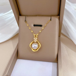 Elegant gold titanium necklace with pearl and diamond pendant in a jewelry box