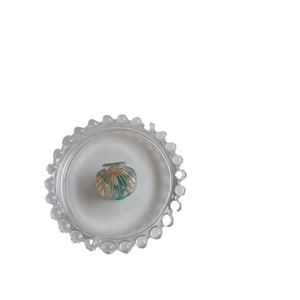 Minimalist acetate shell hair claw with blue marble texture and golden trim on tray