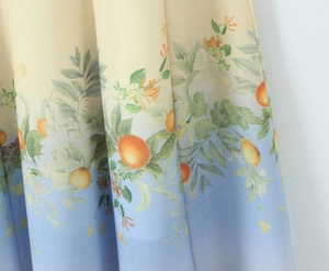 Detailed view of bohemian floral linen fabric with citrus print and gradient blue tones