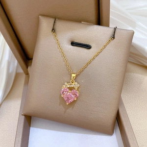 Close-up of pink heart gemstone necklace with a crown pendant in a jewelry box