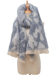 Detailed view of the thick fabric texture and beige tassels on the leopard print scarf