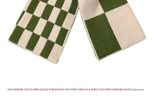 Close-up of green and white checkered knit scarf showing thick woven texture and yarn detail