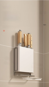 Detail of wall-mounted kitchen knife rack showing drainage tray and wood handle storage