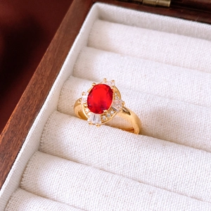 Makrofoto eines Vintage-Goldrings mit ovalem Rubin und weißen Zirkonia-Akzenten
