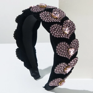 Dettaglio del cerchietto in velluto nero con cuori di cristallo rosa e pietre preziose
