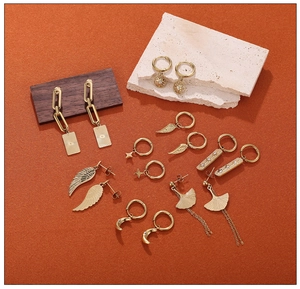 Flat lay of 18K gold plated stainless steel earring set with moon and star pendants