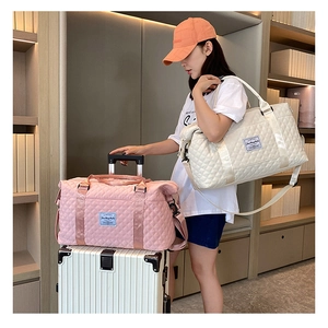 Quilted travel bags in white and pink showing shoulder strap and luggage handle sleeve