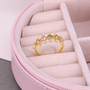 Close-up of golden ring with multi-color gemstones inside a pink jewelry case
