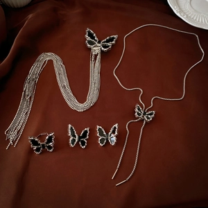 Dark butterfly jewelry set with black gems including necklace, earrings and ring