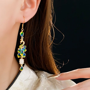 Dettaglio orecchino a piuma di pavone placcato oro 14K con eleganti inserti in smalto