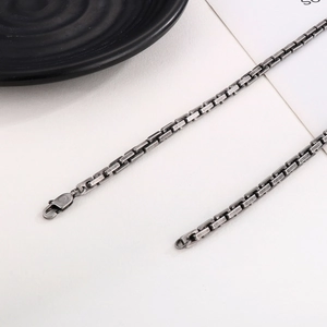 Macro shot of dark grey box chain showing lobster clasp and sturdy metal links structure