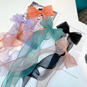 Detail view of colorful organza bow hair clips with long streamers on a magazine