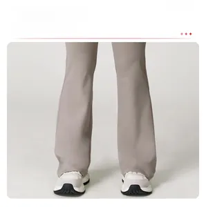 Detail view of the flare leg design on taupe high waisted yoga pants for women