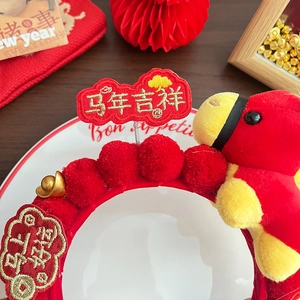 Detailed view of red plush headband with yellow horse doll and festive embroidery
