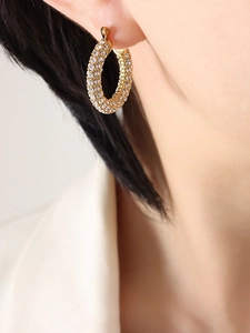 Close-up of 18K gold plated thick hoop earrings with sparkling pave-set zircons on model